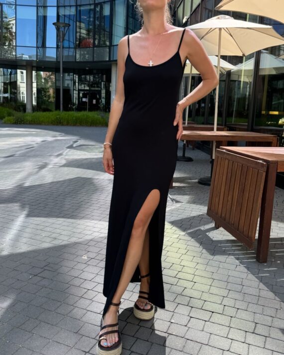 Czarna sukienka maxi z dekoltem V i rozcięciem na nodze prezentowana przez modelkę - przód - lifestyle.