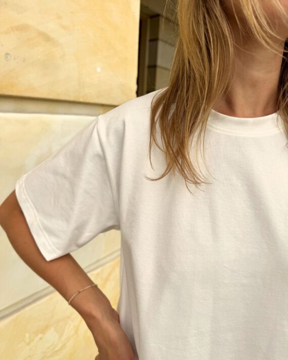 Bawełniany t-shirt w kolorze złamanej bieli na modelce - widok z przodu, detal.