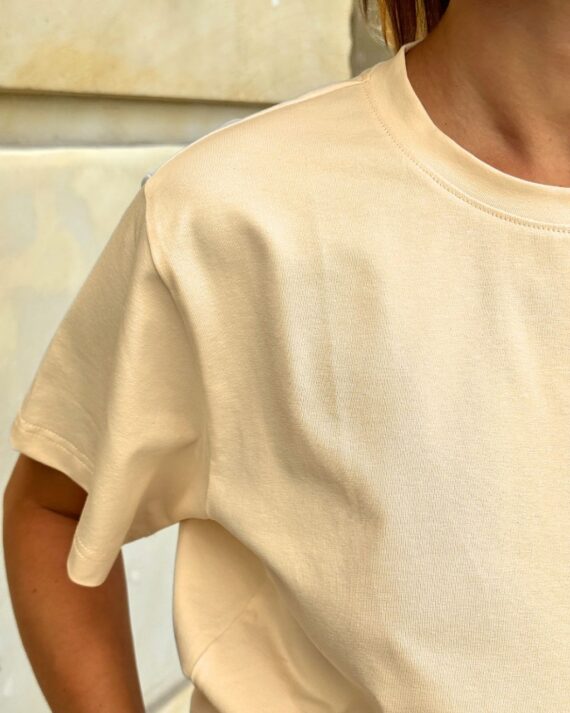 Bawełniany t-shirt ecru na modelce - widok z przodu, detal.